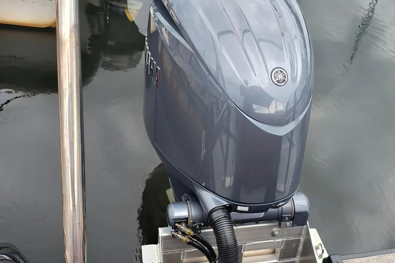 Slide: The Image of Outboard motor on a 2025 SunCatcher Fusion 324RC boat, docked on calm water. - 11
