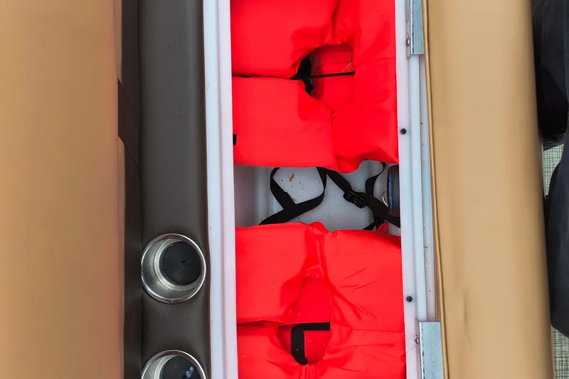 Slide: The Image of Storage compartment with red life jackets on SunCatcher Fusion 324RC, 2025 model. - 14