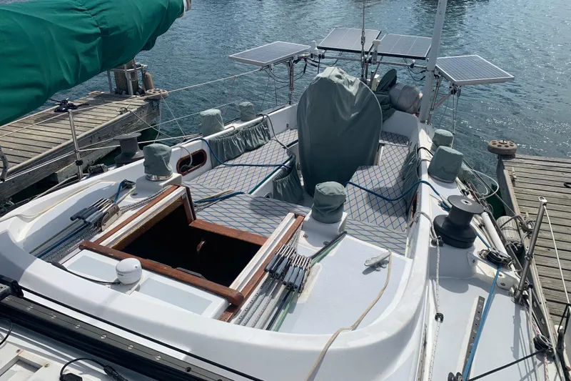 Slide: The Image of 1972 Tartan 41 sailboat docked, featuring solar panels and covered equipment on deck. - 18