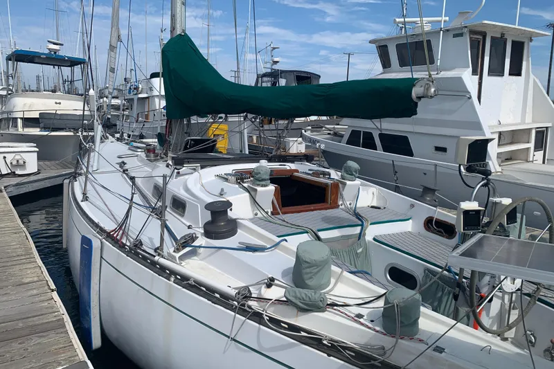 Slide: The Image of 1972 Tartan 41 sailboat docked at marina, featuring green sail cover. - 24