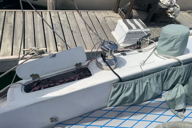 Slide: The Image of 1972 Tartan 41 sailboat deck with winch, ropes, and dock in view. - 26