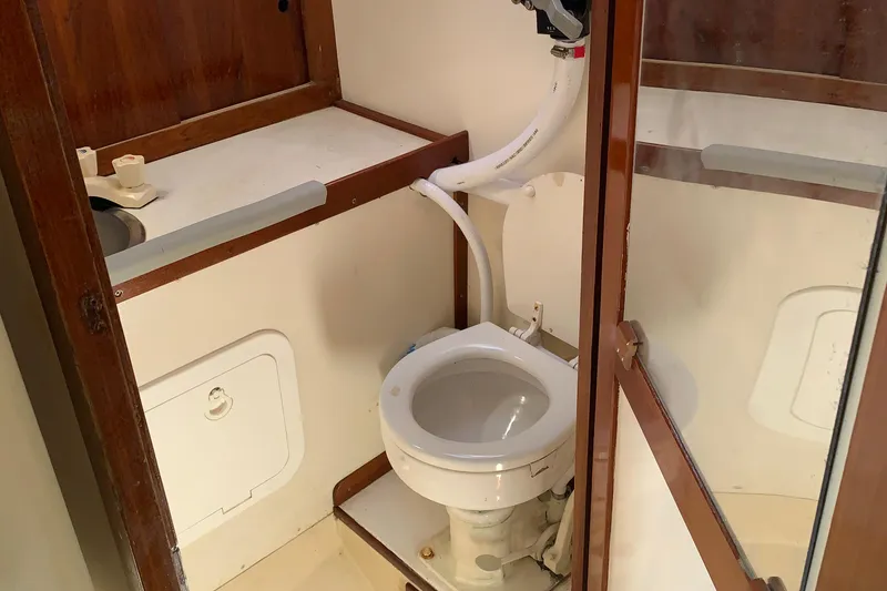 Slide: The Image of 1972 Tartan 41 yacht bathroom with toilet, sink, and wooden cabinetry. - 34