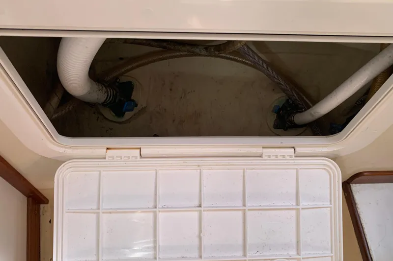 Slide: The Image of Open hatch with visible plumbing in a 1972 Tartan 41 sailboat. - 36