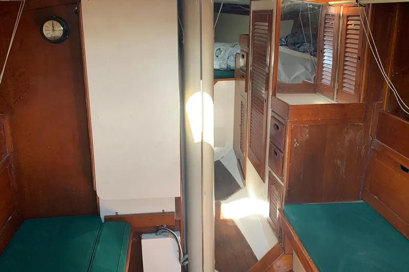 Slide: The Image of Interior of a 1972 Tartan 41 sailboat with wooden cabinetry and green cushions. - 39