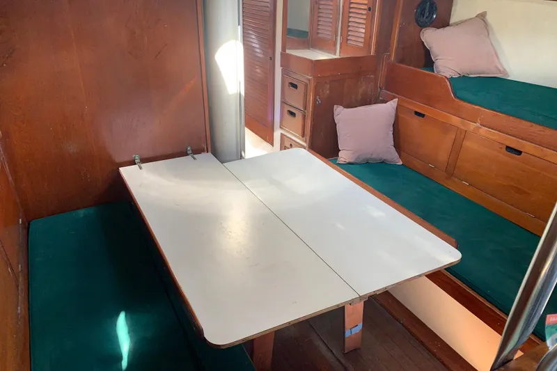 Slide: The Image of Interior of a 1972 Tartan 41 sailboat with wooden furnishings and green cushions. - 42