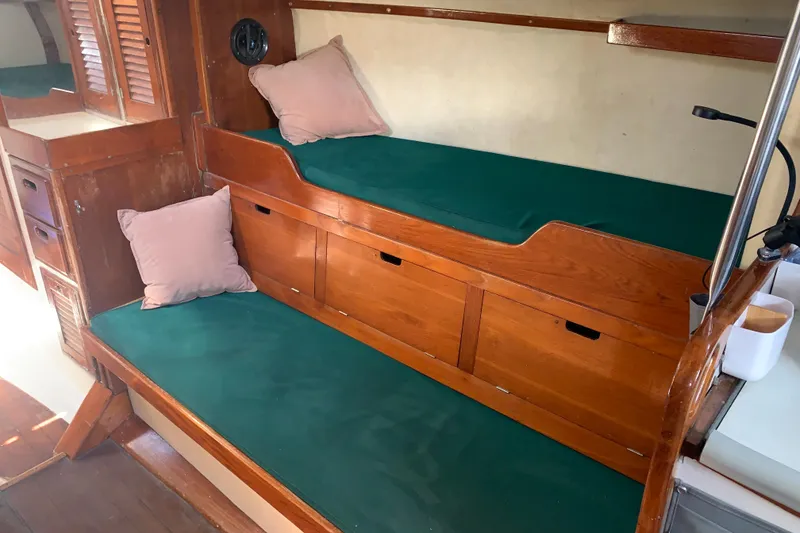 Slide: The Image of Interior of a 1972 Tartan 41 sailboat with green cushioned seating and wooden cabinetry. - 43