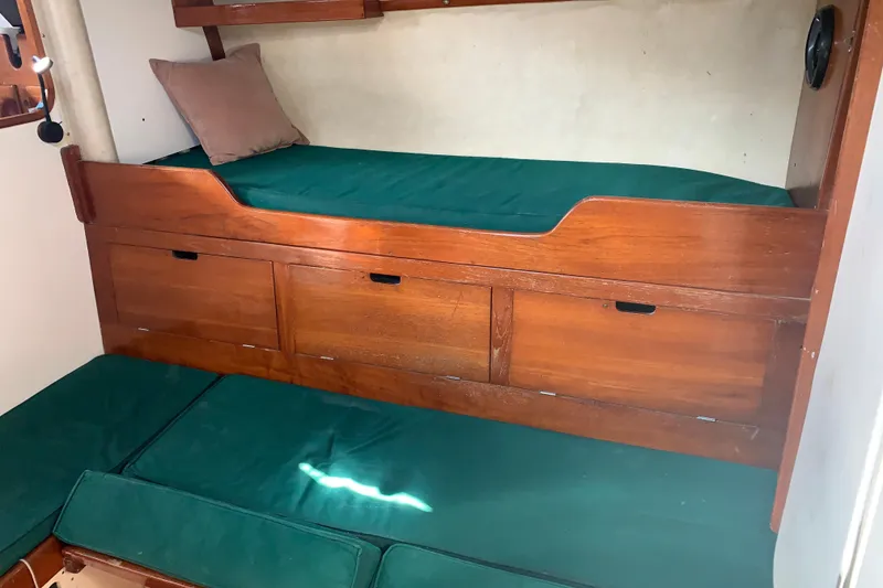 Slide: The Image of 1972 Tartan 41 interior with wooden bunk beds and green cushions. - 45