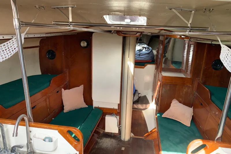 Slide: The Image of Interior of a 1972 Tartan 41 sailboat with wooden furnishings and green cushions. - 49