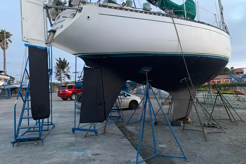Slide: The Image of 1972 Tartan 41 sailboat on stands in a boatyard, with cars and trees nearby. - 5