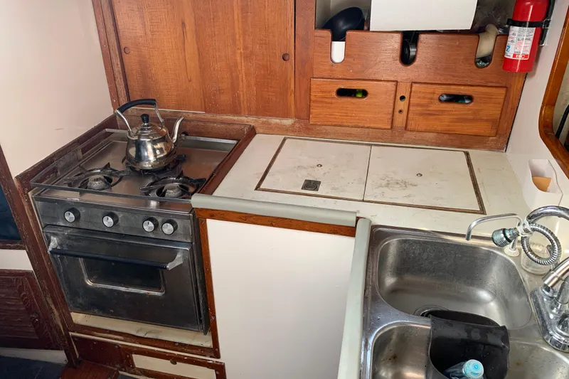 Slide: The Image of 1972 Tartan 41 yacht kitchen with stove, sink, and wooden cabinets. - 51