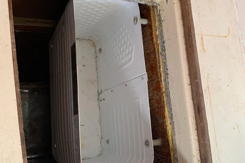 Slide: The Image of Interior view of a 1972 Tartan 41 sailboat, showcasing a compartment with a white panel. - 53