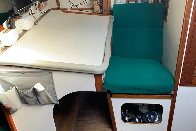 Slide: The Image of 1972 Tartan 41 yacht interior with green cushions and navigation station. - 57