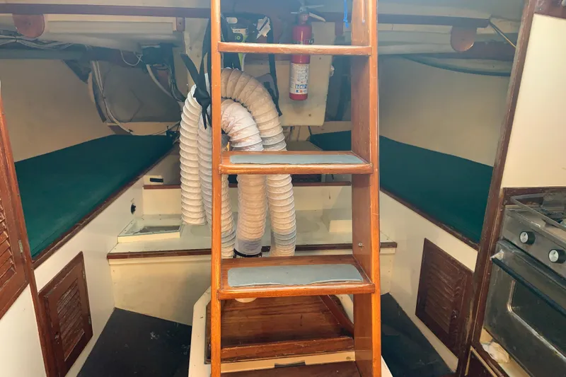 Slide: The Image of Interior of a 1972 Tartan 41 sailboat with wooden ladder and green cushions. - 67