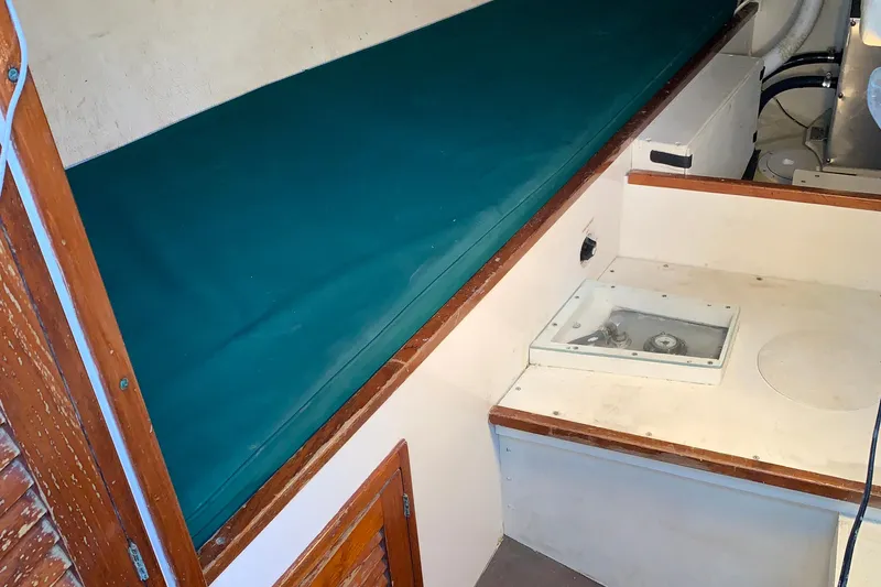Slide: The Image of Interior of a 1972 Tartan 41 sailboat with teal cushioned seating. - 73