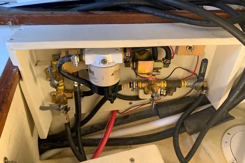 Slide: The Image of Engine compartment of a 1972 Tartan 41 sailboat, featuring fuel lines and filter system. - 74