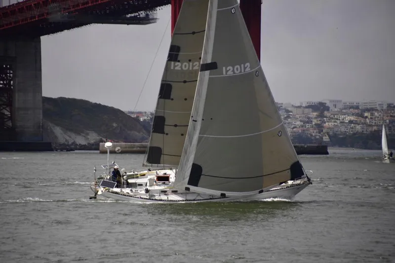 Slide: The Image of Sailing yacht Tartan 41 (1972) under bridge, cityscape in background. - 9