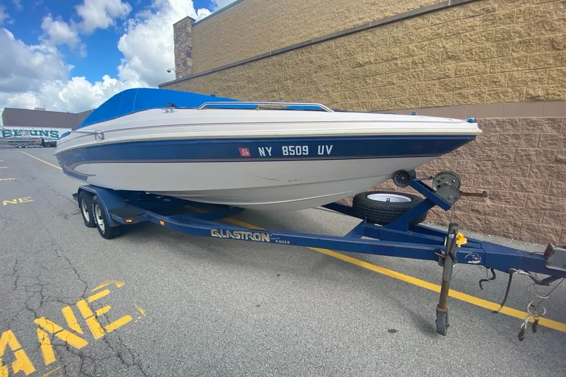 Slide: The Image of 1998 Glastron/Carlson GS225 boat on trailer, parked near a brick wall. - 2