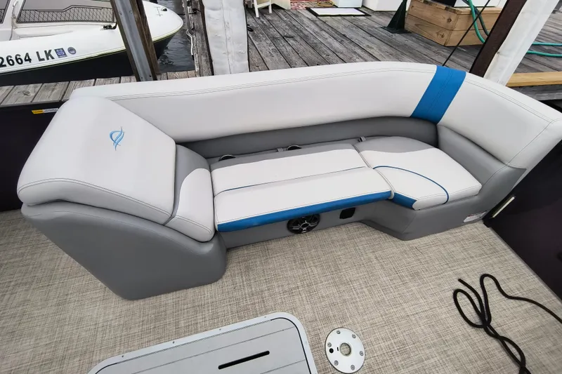 Slide: The Image of 2025 SunCatcher Select 324RC boat seating with gray and blue upholstery on a dock. - 13