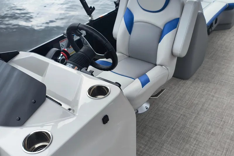Slide: The Image of 2025 SunCatcher Select 324RC boat interior with steering wheel and comfortable seating. - 19