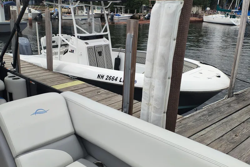 Slide: The Image of 2025 SunCatcher Select 324RC boat docked at marina, featuring sleek design and comfortable seating. - 8