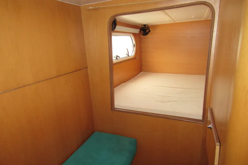 Slide: The Image of Interior cabin of 2001 Catana 471 yacht with wooden paneling and a cozy bed. - 109