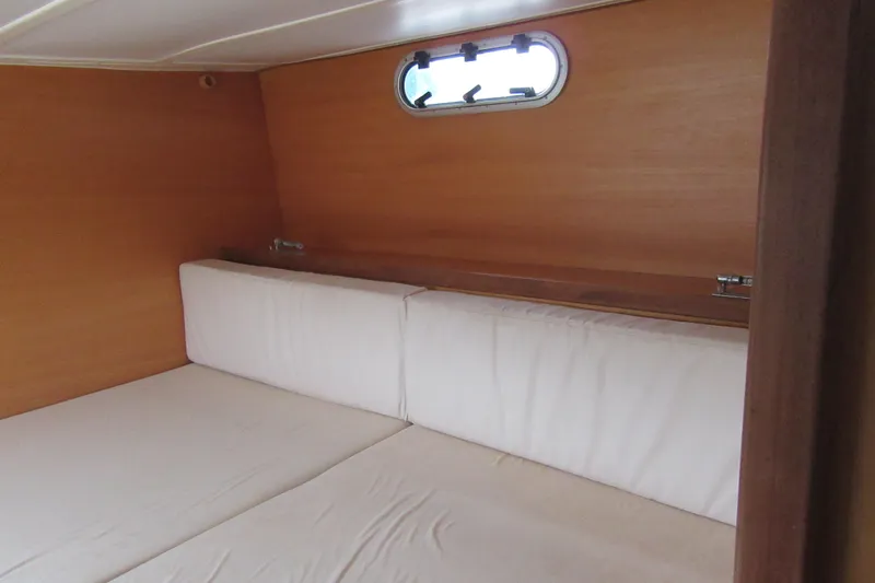 Slide: The Image of Interior cabin of 2001 Catana 471 yacht with wooden walls and white cushions. - 111
