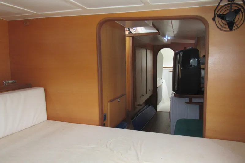 Slide: The Image of Interior of 2001 Catana 471 yacht, featuring wooden paneling and compact living space. - 114