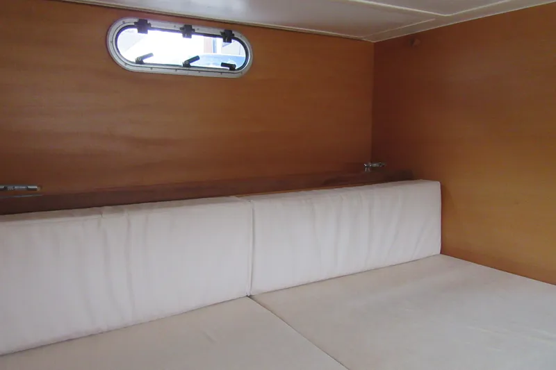 Slide: The Image of Interior cabin of 2001 Catana 471 yacht with wooden walls and white cushions. - 115