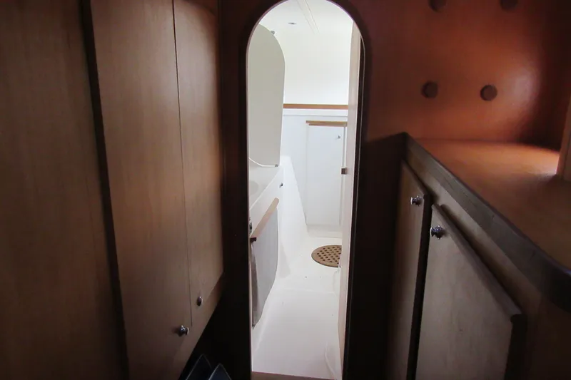 Slide: The Image of Interior view of 2001 Catana 471 yacht, featuring wooden cabinetry and a compact bathroom. - 118