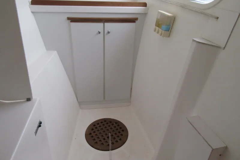 Slide: The Image of Interior of 2001 Catana 471 yacht, featuring a compact white bathroom with storage cabinet. - 120