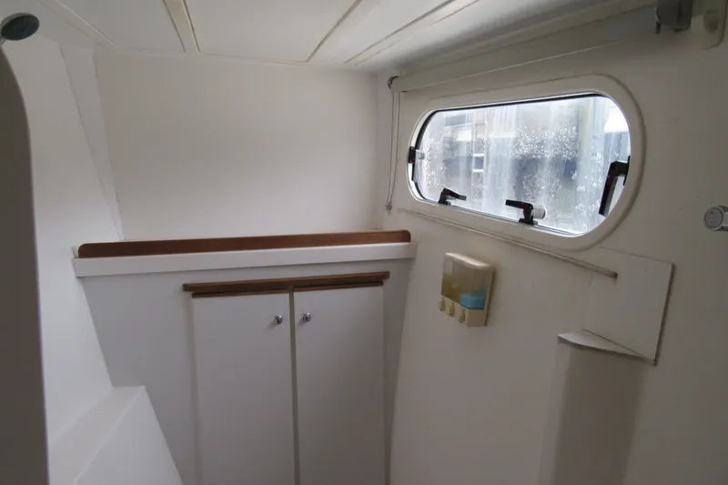 Slide: The Image of Interior of a 2001 Catana 471 yacht, featuring a window and storage cabinets. - 121