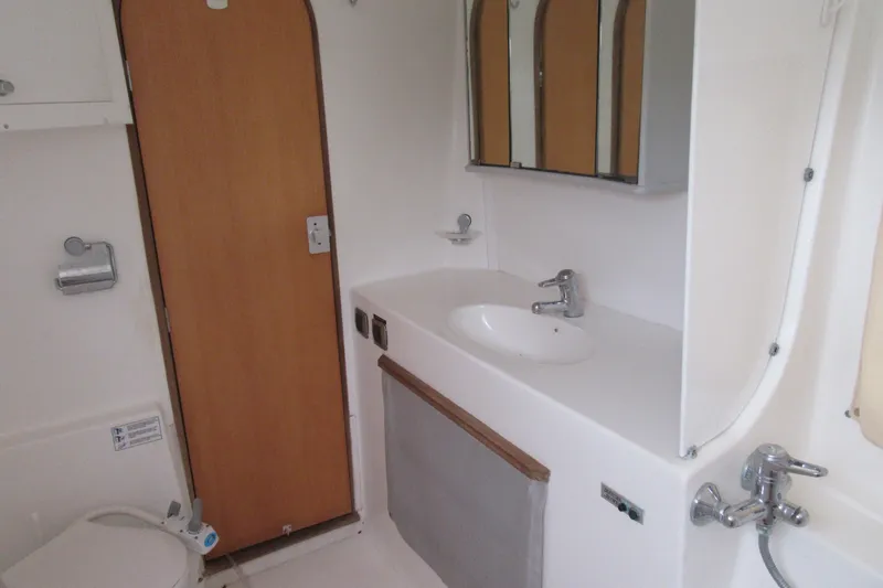 Slide: The Image of Bathroom interior of 2001 Catana 471 yacht with sink, mirror, and wooden door. - 123
