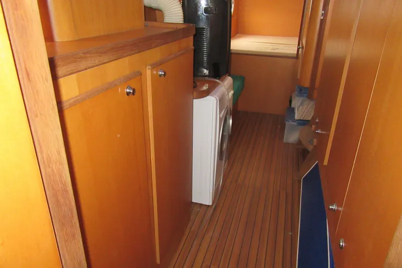 Slide: The Image of Interior of 2001 Catana 471 yacht with wooden cabinets and washing machine. - 127