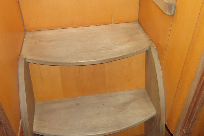 Slide: The Image of Wooden steps inside a 2001 Catana 471 yacht, featuring curved design and warm tones. - 129