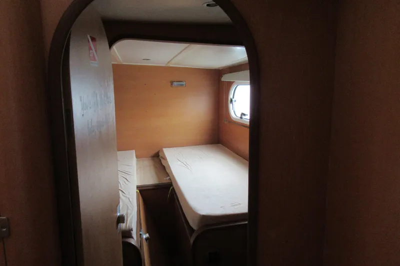 Slide: The Image of Interior cabin of a 2001 Catana 471 yacht with twin beds and a porthole window. - 137