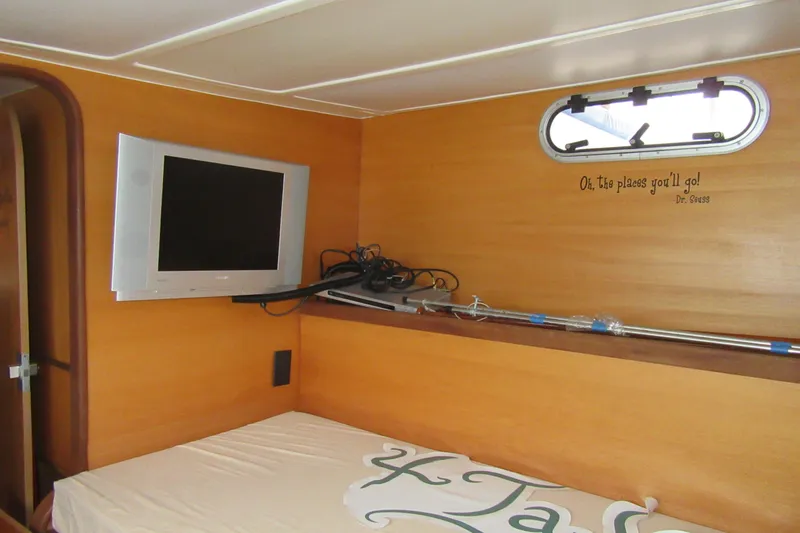 Slide: The Image of Cozy Catana 471 cabin interior with TV, porthole, and Dr. Seuss quote on wall. - 141