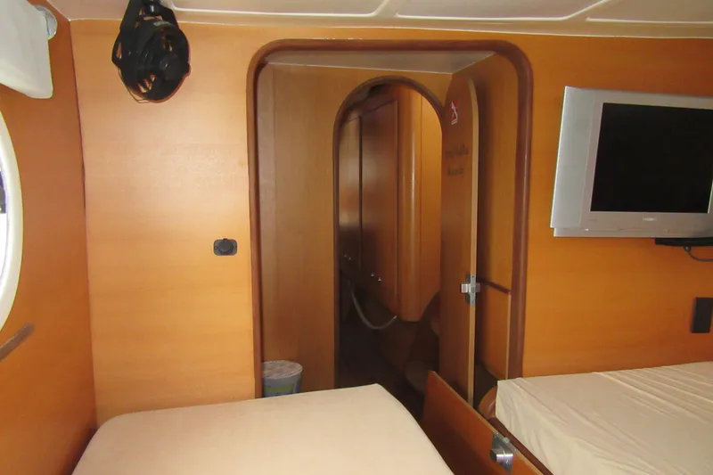 Slide: The Image of Interior of 2001 Catana 471 yacht cabin with wooden finish and mounted TV. - 142
