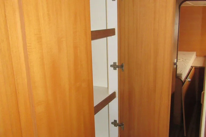 Slide: The Image of Interior of 2001 Catana 471 yacht showing wooden cabinetry and storage space. - 147