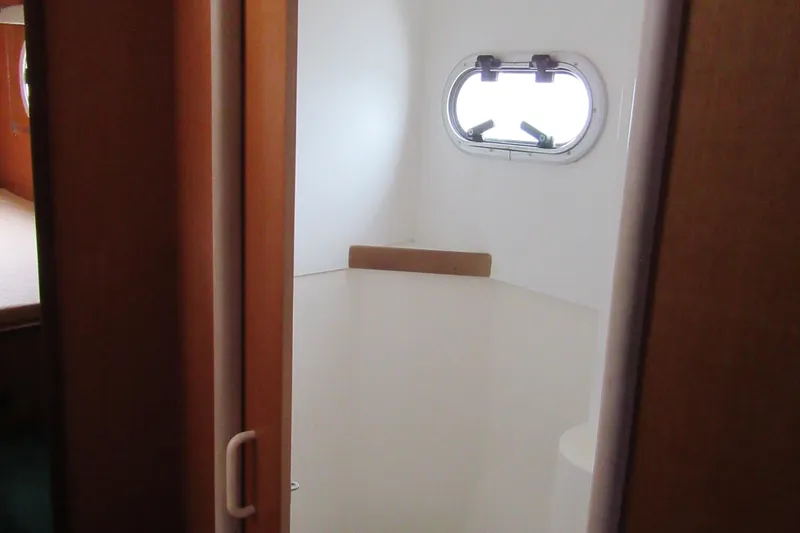 Slide: The Image of Interior of 2001 Catana 471 yacht, featuring a small cabin with a porthole window. - 148