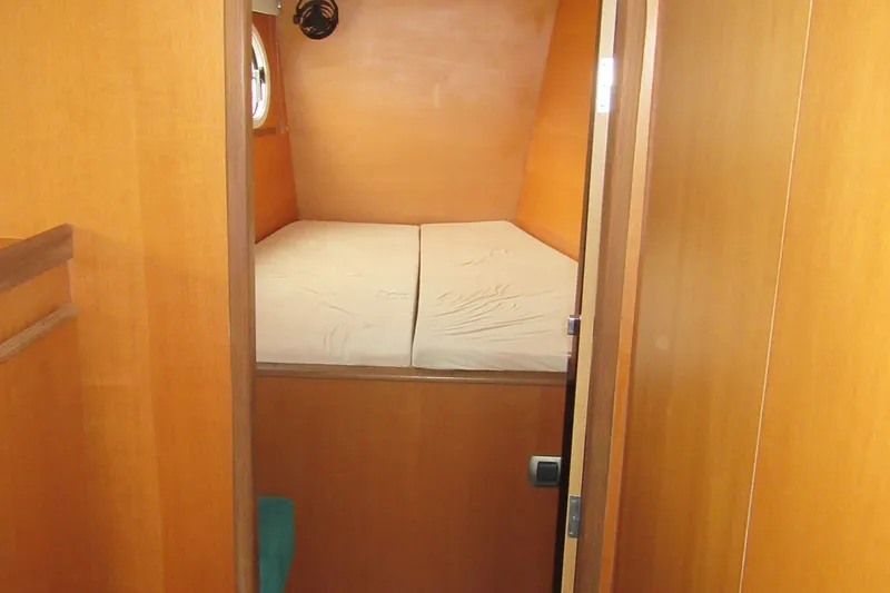 Slide: The Image of Cozy cabin interior of 2001 Catana 471 yacht with wooden finish and bed. - 151
