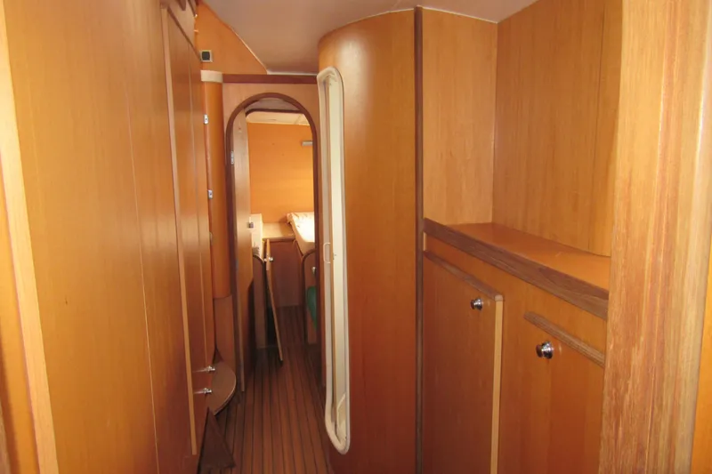 Slide: The Image of Interior of 2001 Catana 471 yacht, featuring wooden cabinetry and hallway. - 155
