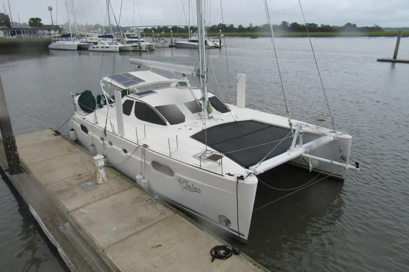 Slide: The Image of 2001 Catana 471 catamaran docked at a marina with solar panels on deck. - 164