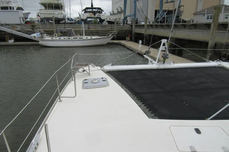 Slide: The Image of Catana 471 catamaran docked at marina, 2001 model, with visible deck and netting. - 18