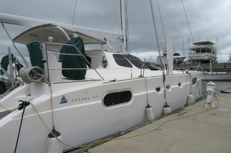 Slide: The Image of 2001 Catana 471 catamaran docked at marina under cloudy skies. - 2