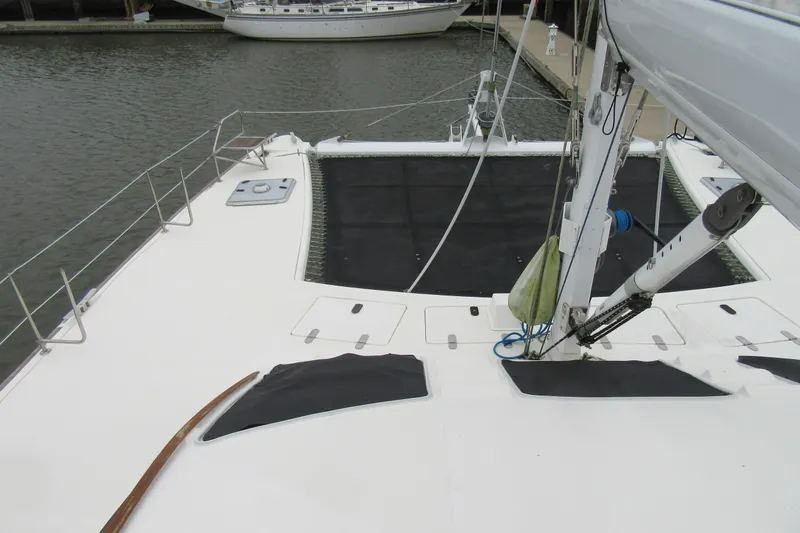 Slide: The Image of 2001 Catana 471 catamaran deck view with rigging and netting, docked in marina. - 40