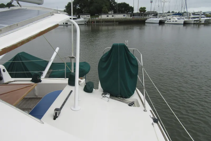 Slide: The Image of 2001 Catana 471 yacht docked at marina, featuring covered equipment and solar panels. - 54