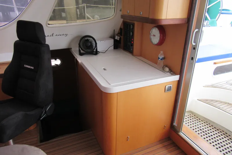 Slide: The Image of Interior of 2001 Catana 471 yacht with control panel, chair, and wooden cabinetry. - 94