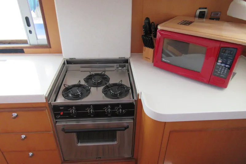 Slide: The Image of Galley kitchen in 2001 Catana 471 yacht with stove and red microwave. - 98