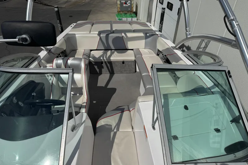 Slide: The Image of 2006 Moomba Mobius XLV boat interior with white and gray seating, open windshield, and steering wheel. - 8