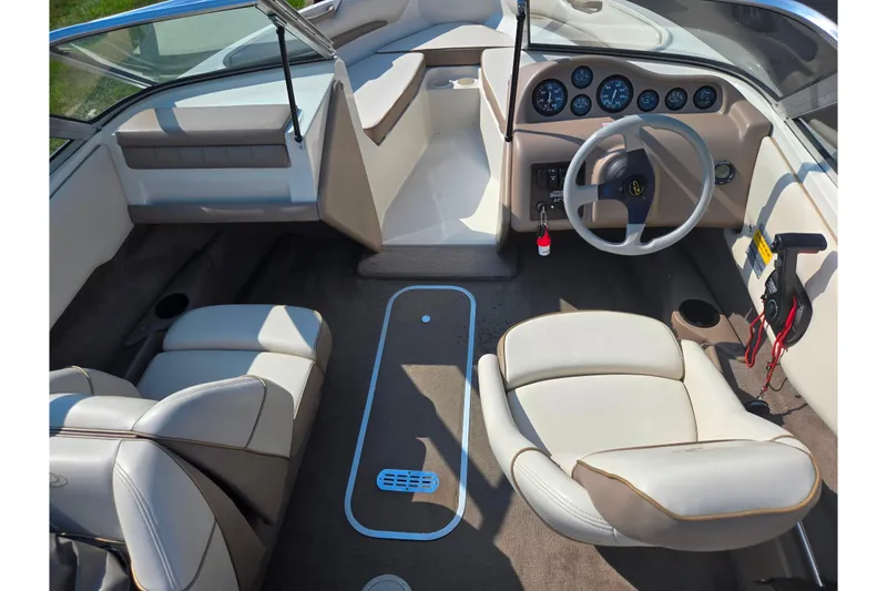 Slide: The Image of 1998 Regal Valanti 176 boat interior with beige seating and dashboard controls. - 11